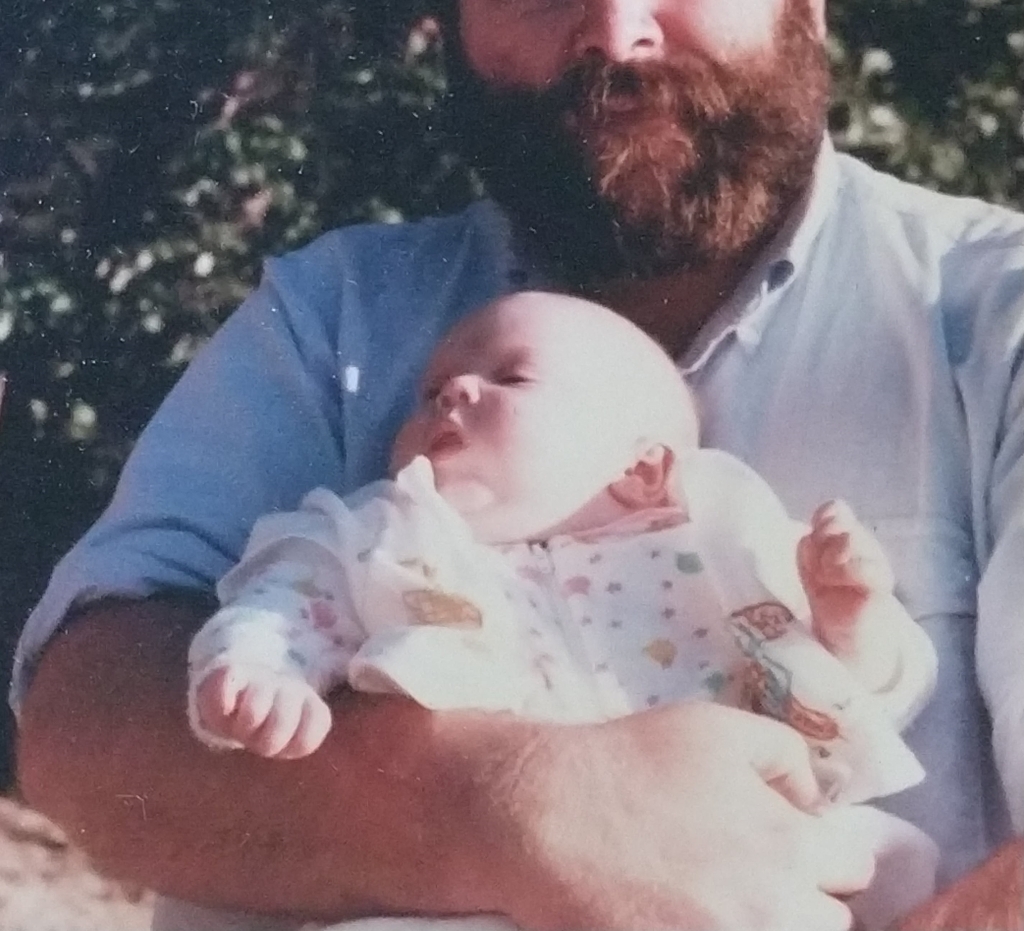 cropped photo of bearded dad holding infant daughter